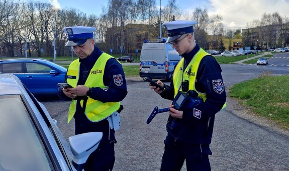 Dwaj policjanci w czasie kontroli drogowej pojazdu.