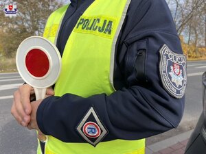 zdjęcie przedstawiające policjanta z Wydziału Ruchu Drogowego w żółtej odblaskowej kamizelce