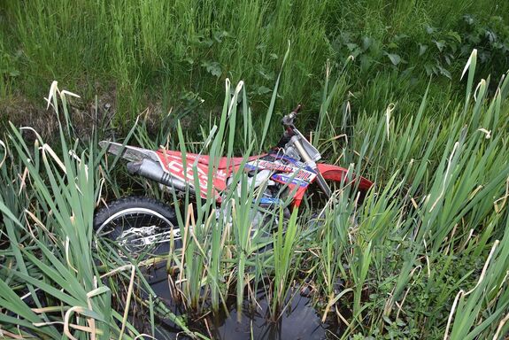 Motocykl leżący w szuwarach