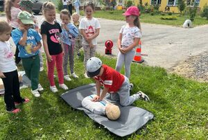 Dzieci ćwiczą udzielanie pierwszej pomocy na fantomie