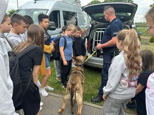 Policjant z policyjnym psem rozmawia z dziećmi