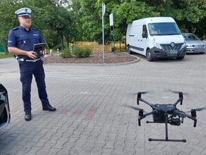 Policjant operuje dronem.