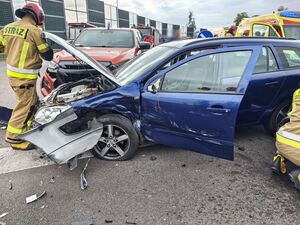 Uszkodzone samochody, przy których pracują strażacy