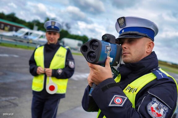 Policjanci prowadzą pomiar prędkości przy drodze.