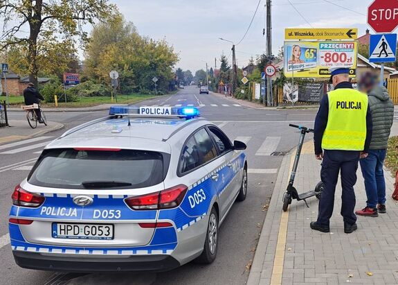 Policjant kontroluje mężczyznę na hulajnodze.