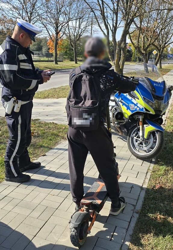 Policjant kontroluje mężczyznę na hulajnodze.