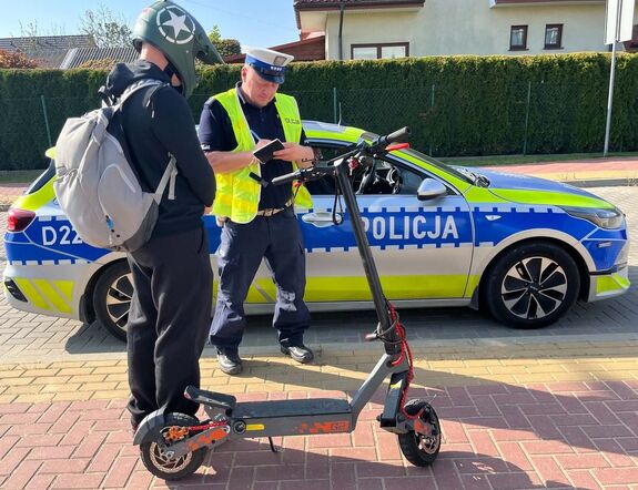 Policjant podczas kontroli drogowej kierującego hulajnogą.