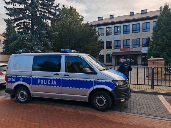 Policyjny radiowóz stojący przed szkołą.