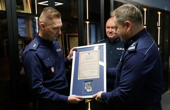 Podkomisarz Paweł Burda z rąk Komendanta Wojewódzkiego Policji w Lublinie inspektora Tomasza Gila otrzymuje pamiątkowy ryngraf.