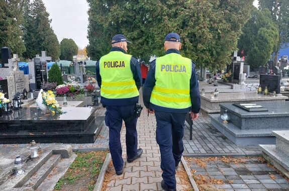 Policjanci patrolują teren cmentarza.
