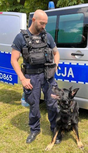 Policjant z psem przy radiowozie