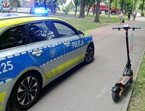 radiowóz i stojąca obok hulajnoga elektryczna